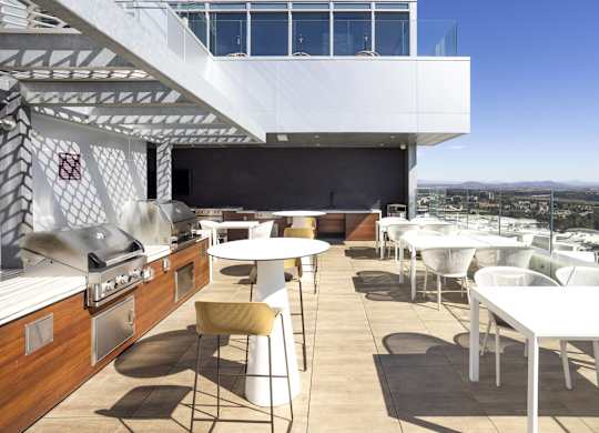 Rooftop kitchen with grill and outdoor dining at LUX by Garden* Apartments, San Diego