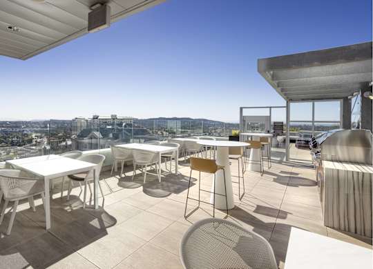 Rooftop dining terrace with outdoor kitchen and city views at LUX by Garden* Apartments, California