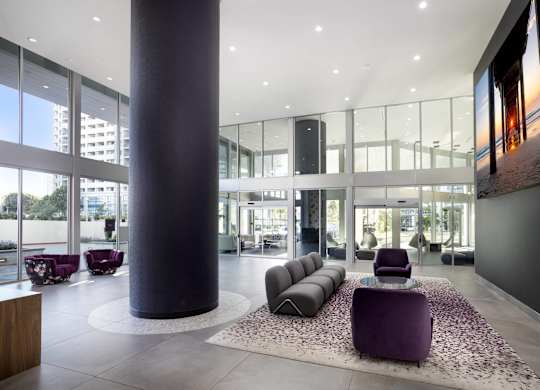 Modern lobby with curved seating and column at LUX by Garden* Apartments, San Diego, CA