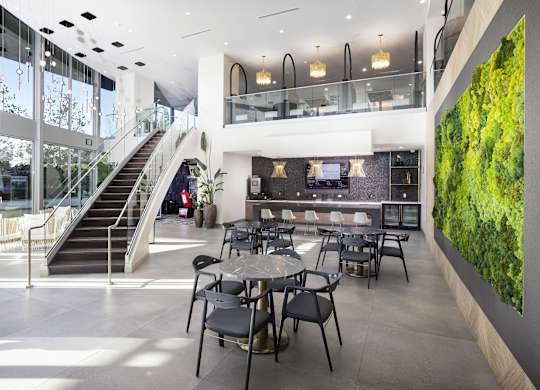 Resident dining area with living wall and staircase at LUX by Garden* Apartments, San Diego, California