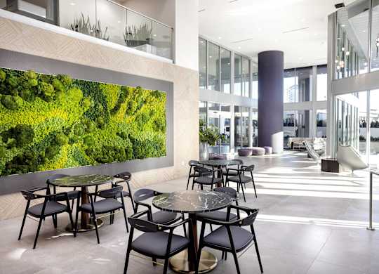 Modern lobby with moss wall and dining tables at LUX by Garden* Apartments, San Diego
