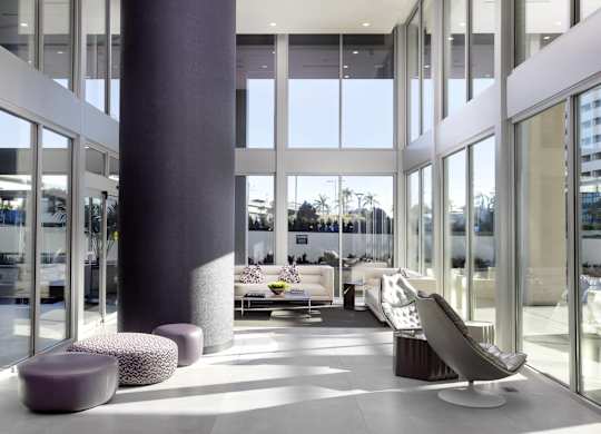 Modern lobby with double height windows and seating at LUX by Garden* Apartments, California
