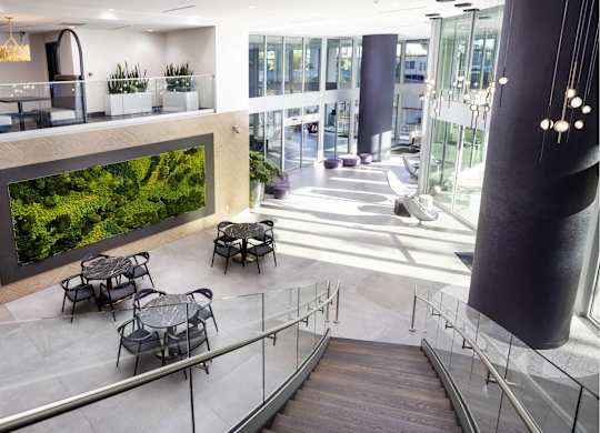 Two story atrium with living moss wall and seating at LUX by Garden* Apartments, San Diego, CA 92122