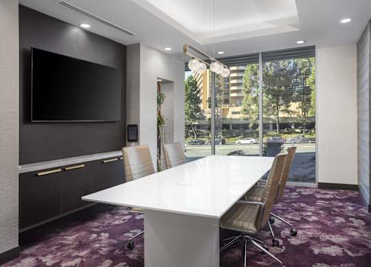 Conference room with large table and flat screen tv at LUX by Garden* Apartments, San Diego, California