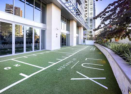 Outdoor shuffleboard court on synthetic turf with planters at LUX by Garden* Apartments, San Diego, CA 92122