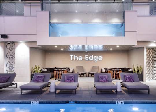 Indoor pool with lounge chairs and decorative wall at LUX by Garden* Apartments, San Diego