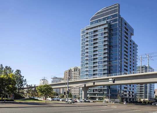 Modern high rise building with elevated transit line at LUX by Garden* Apartments, San Diego, CA
