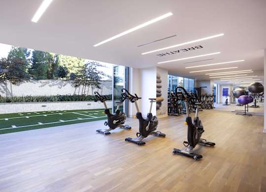 Fitness center with stationary bikes and turf training area at LUX by Garden* Apartments, San Diego, CA