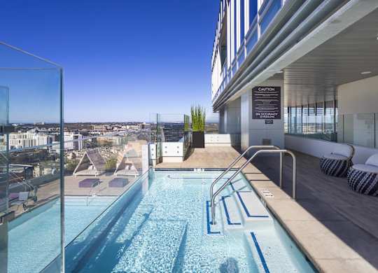 Rooftop pool with glass railing and city views at LUX by Garden* Apartments, San Diego, 92122