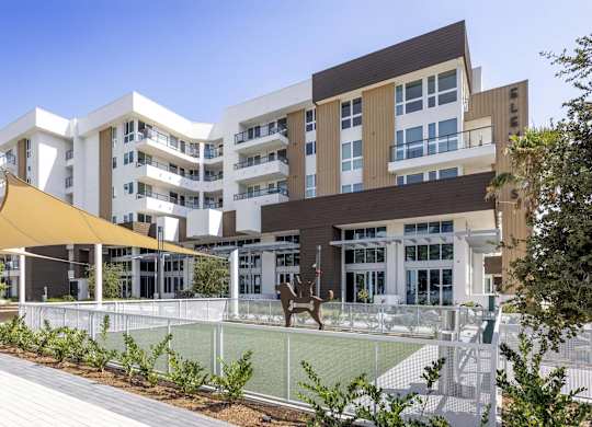 Modern apartment building with dog park and shade structure at Elements Apartments, Irvine