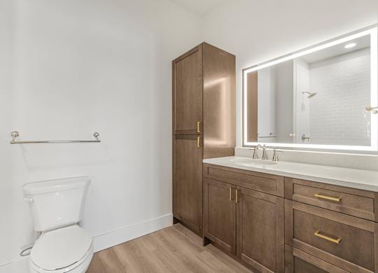 A white toilet sits next to a wooden medicine cabinet and vanity.