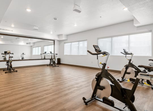 a gym with white walls and hardwood flooring