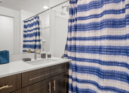 a bathroom with a sink and shower in a 555 waverly unit