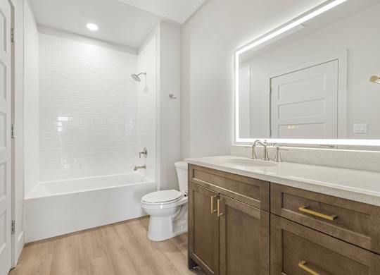 A white bathroom with a toilet, sink, and a walk-in shower.