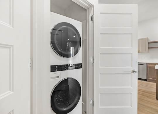 A white door opens to a modern kitchen.