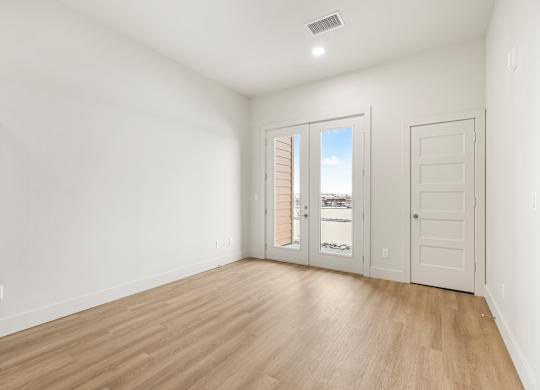 A room with a sliding glass door leading to a balcony.