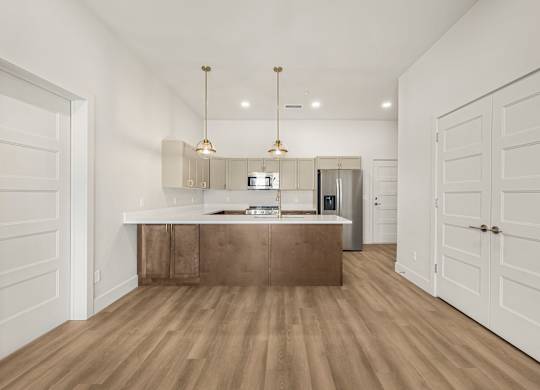 A kitchen with a wooden floor and white walls.