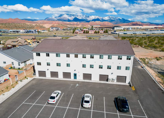 a large white building with cars in a parking lot