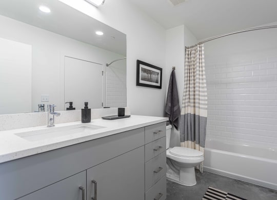 a white bathroom with a shower and a sink