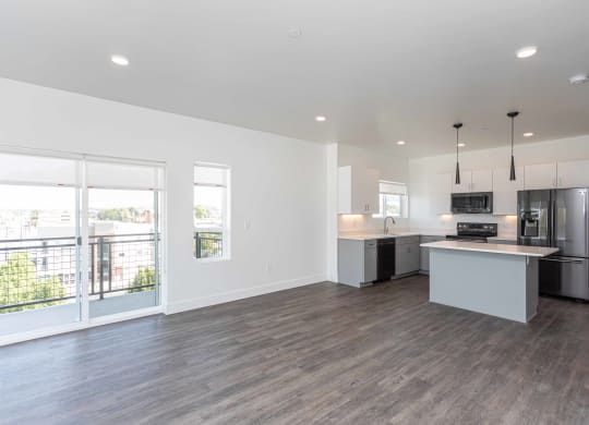 a living room with a kitchen and a large window