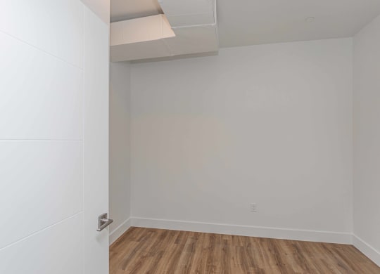 an empty room with white walls and a wooden floor