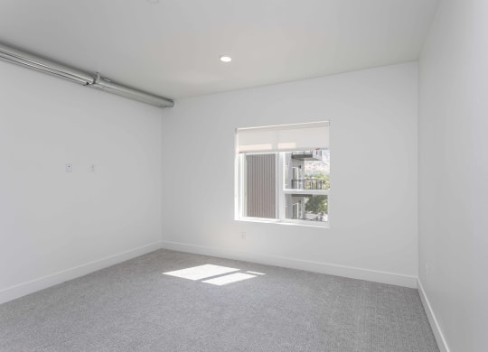 a living room with white walls and a window