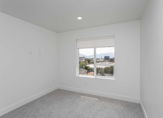 an empty room with a window overlooking a city