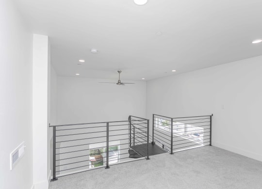 a large empty room with a metal railing