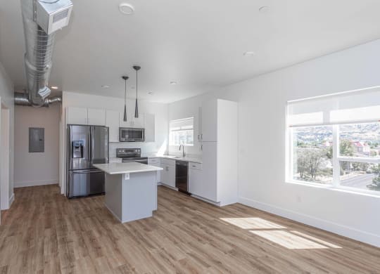 an empty kitchen with white walls and wood floors