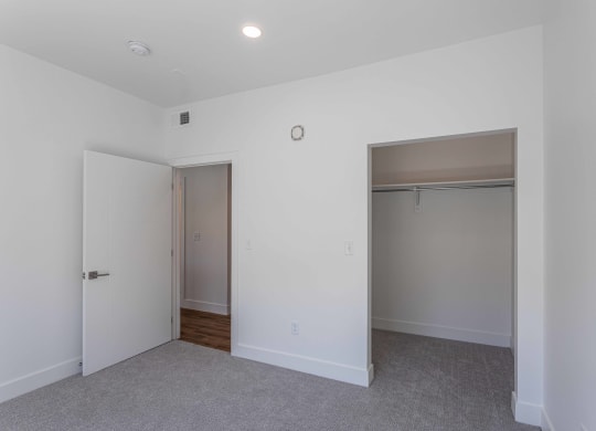 an empty bedroom with a closet and a door to a bathroom
