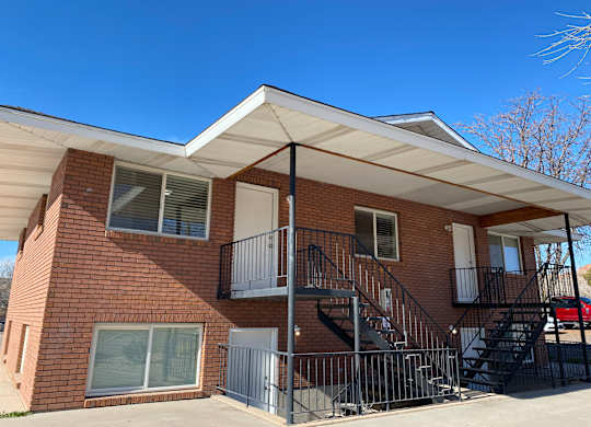A red brick house with a black metal staircase.