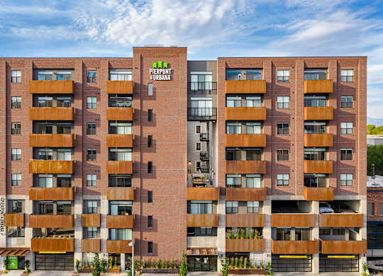 a large apartment building with a green logo on the side of it