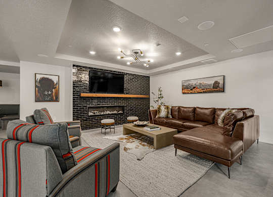 A living room with a fireplace and a brown couch.