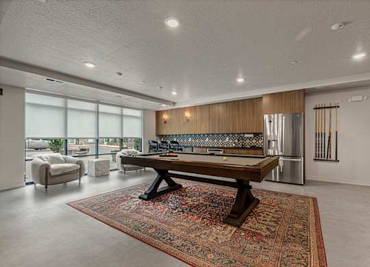 A modern living room with a large rug and a wooden coffee table.