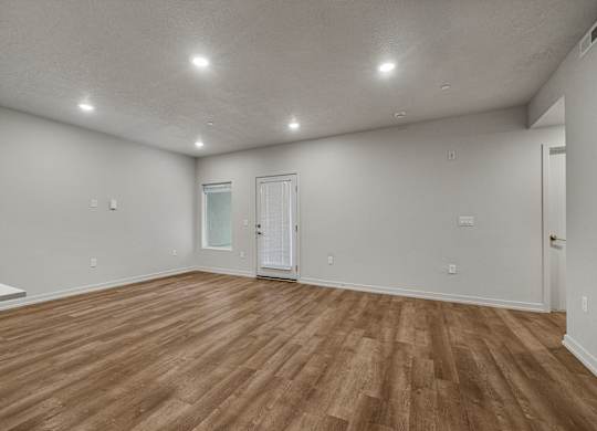 A room with wooden flooring and white walls.