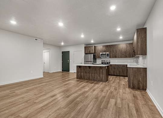 A kitchen with wooden floors and cabinets.
