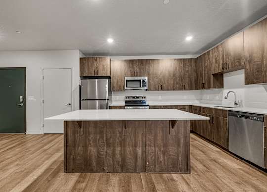A modern kitchen with wooden cabinets and stainless steel appliances.