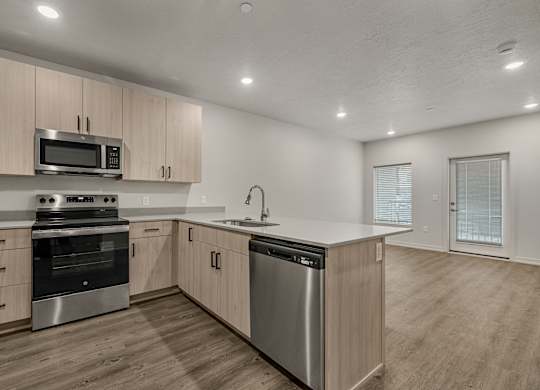 A modern kitchen with stainless steel appliances and wooden cabinets.