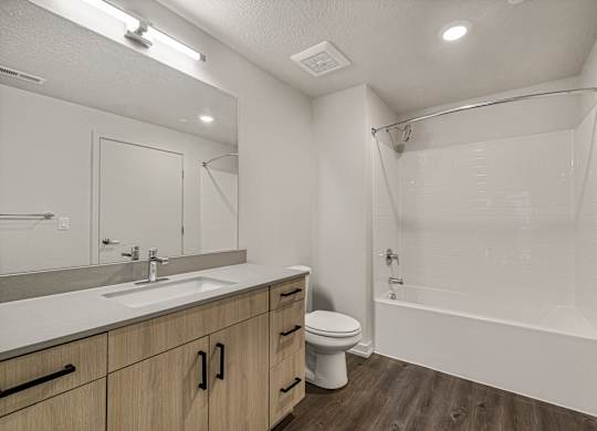 A white bathroom with a sink, toilet, and bathtub.