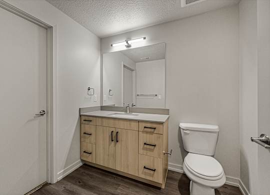 A bathroom with a toilet, sink, and medicine cabinet.
