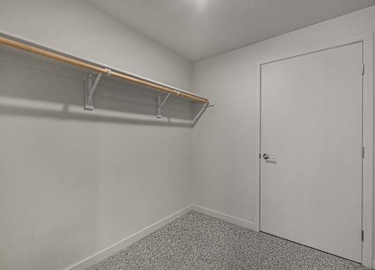 A white door is closed in a room with a grey carpet.