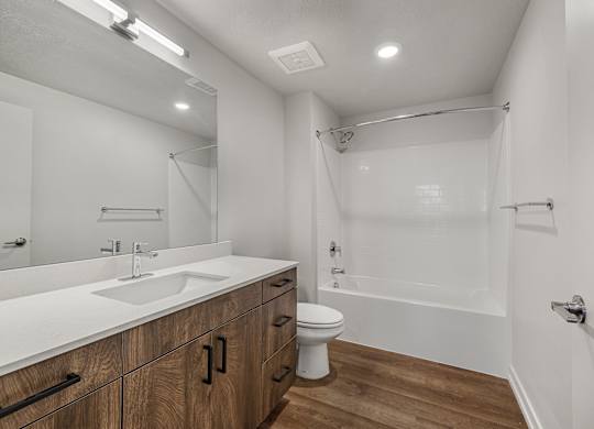 A white bathroom with a sink, toilet, and bathtub.
