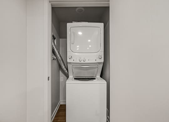 A white washing machine is in a small alcove.