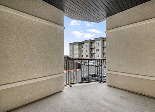 A view from inside a building looking out to a parking lot and other buildings.