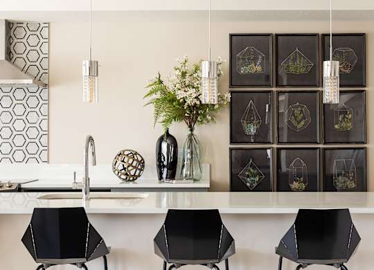 A kitchen with a white counter top and black bar stools.