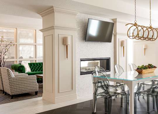 A living room with a fireplace, a television, and a dining table set for four.