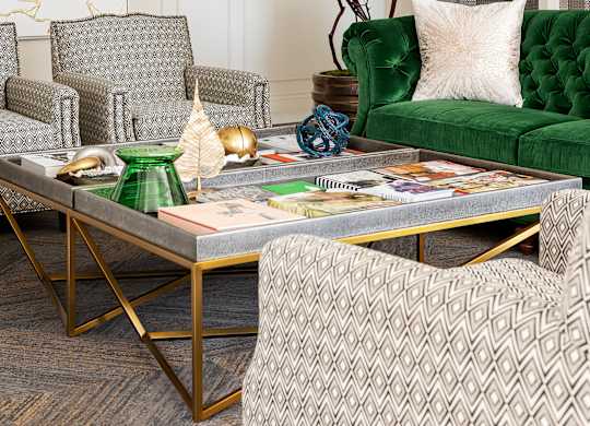 A living room with a green sofa and a patterned rug.