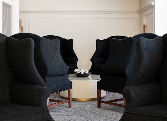 Two black chairs facing each other with a table in between.