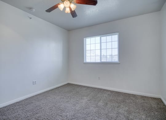 a bedroom with a ceiling fan and a window
