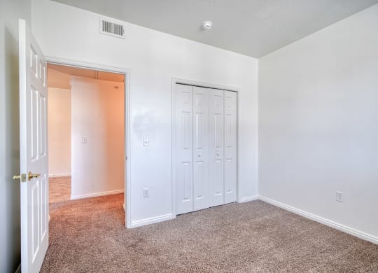 a bedroom with white walls and carpet